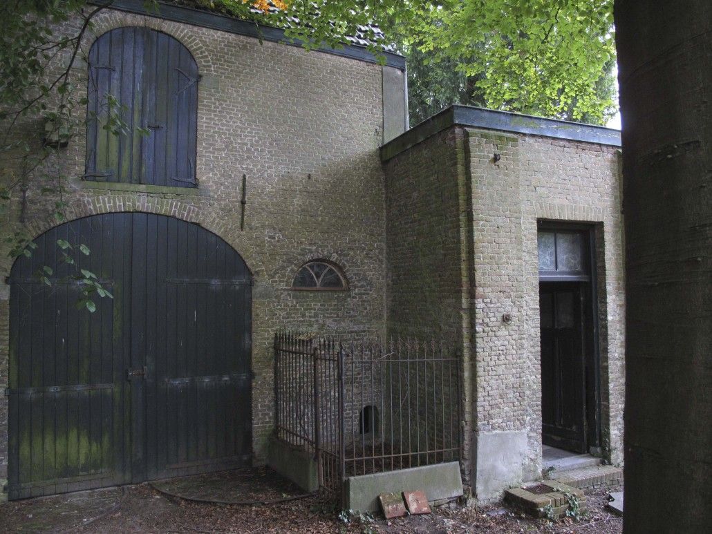 Het koetshuis links met rechts de deur van de koetsierswoning in het stalgebouw.